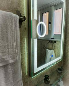 a bathroom with a mirror and a sink with a towel at Filanthis inn in Kalamata +22 photos