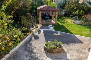 a garden with a gazebo and a dog in a yard at Filanthis inn in Kalamata