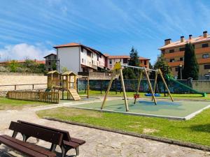 een park met een speeltuin met een glijbaan en een bank bij Apartamento en Colombres in Colombres