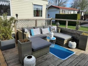 un patio con muebles de mimbre en una terraza de madera en Family Home Grill, Beach, Relax - WORKUM, en Workum