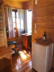 a room with a refrigerator and a table with wine glasses at Hospedagem Família Cruz in Urubici