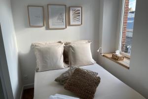 - une chambre avec un lit doté d'oreillers blancs et d'une fenêtre dans l'établissement L'amiral n2 T2 nouvelle ville ByLocly, à Lorient