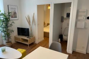 un salon avec une télévision et une chambre avec un lit dans l'établissement L'amiral n2 T2 nouvelle ville ByLocly, à Lorient