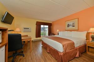 a hotel room with a bed and a desk and a television at Super 8 by Wyndham Rapid City in Rapid City