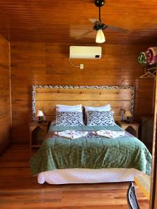 a bedroom with a bed with a wooden wall at Hospedagem Família Cruz in Urubici