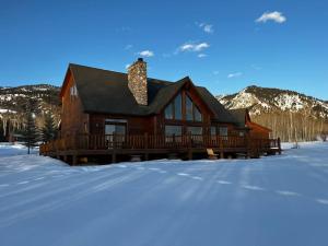 una grande casa in legno nella neve con le montagne di MAJESTIC VIEWS FAMILY LODGE with Large Deck a Thayne