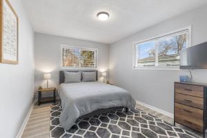 ein Schlafzimmer mit einem Bett und zwei Fenstern in der Unterkunft Entire Home Near MSU and Local Hospitals with Fast Wi-Fi & Dedicated Office in Lansing