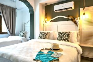 a hotel room with a bed with a hat on it at Liman Hotel Gümüslük - Adult Only in Bodrum City