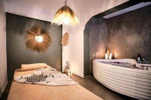 a bathroom with a large bath tub and a large bed at Liman Hotel Gümüslük - Adult Only in Bodrum City