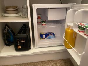 an open refrigerator with orange juice and a toaster at Seven Oaks B&B in Ballyhaunis