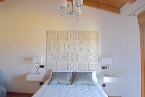 a bedroom with a bed and a chandelier at Casa Rural La Cueva del Agua in Fuentetoba