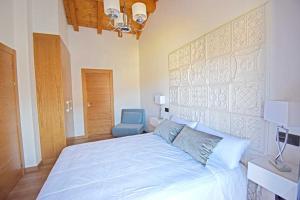 a bedroom with a large bed and a blue chair at Casa Rural La Cueva del Agua in Fuentetoba