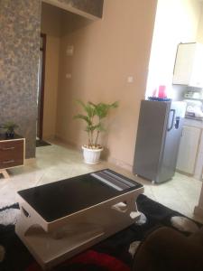 a kitchen with a table and a refrigerator at Brooks apartments in Kampala