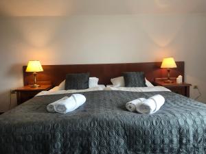a hotel room with a large bed with towels on it at Willa Anna - Pokoje Gościnne in Goczałkowice-Zdrój