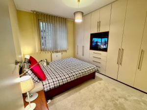 Dormitorio pequeño con cama y TV en New HALA WiFi 70’TV Netflix HBO Max AppletTV+, en Varsovia
