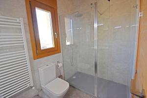 a bathroom with a toilet and a glass shower at Casa Rural La Cueva del Agua in Fuentetoba +10 photos