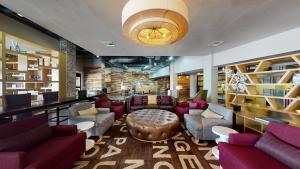 a lobby with a library with couches and a table at Aggieland Boutique Hotel in College Station