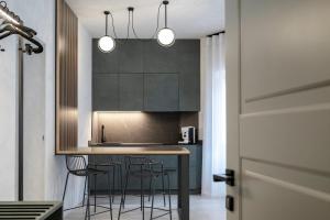 a kitchen with black cabinets and a counter with stools at Dome in Catania