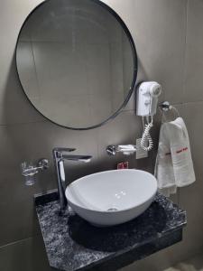 a bathroom with a sink with a large mirror at HOTEL REGIS in Buenos Aires