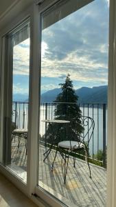 een balkon met een tafel en stoelen bij Casa Mille Luci in Argegno