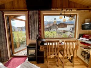 cocina con mesa, 2 sillas y ventana en Tiny House Singer - contactless check-in - Sauna en Ehenbichl