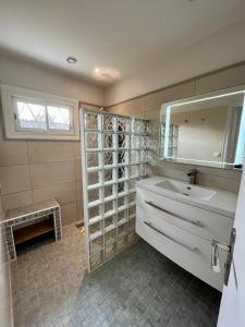 ein Badezimmer mit Waschbecken und Spiegel in der Unterkunft Villa Petit-Père - à 400m de la plage in Taussat-les-Bains + 18 Fotos