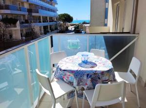 uma mesa numa varanda com uma mesa e cadeiras em NIAGARA Resort Green Life Residence em Bibione