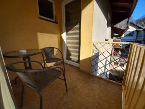 patio con mesa y sillas en el balcón en Apartman Lotus, en Kiseljak