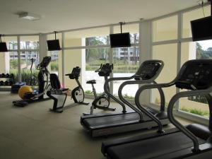 a gym with several tread machines in a room at Green Park Apartamentos in Punta del Este