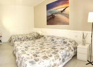 um quarto com duas camas e um quadro na parede em NIAGARA Resort Green Life Residence em Bibione