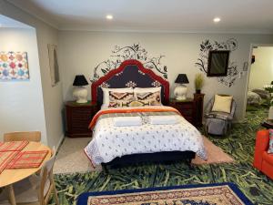 um quarto com uma cama grande, uma mesa e cadeiras em Highlands Riad em Moss Vale
