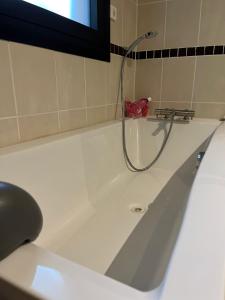 Chambre d'hôtes "Sur la route des Terrils" في فوندا لو فييْ: حوض استحمام مع دش مع خرطوم