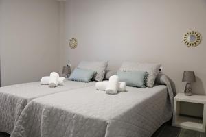 a bedroom with two beds with towels on them at Apartamentos Credencial in Sarria