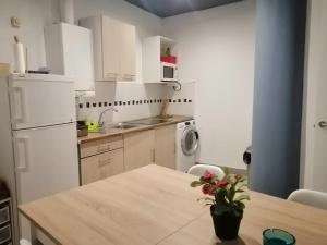 a kitchen with a table and a white refrigerator at Good morning RH Santander - Hostel in Santander