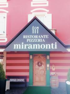 um edifício cor-de-rosa com um cartaz que lê Joy, a histórica pula minnesota em Miramonti B&B cucina&pizza em Brentonico