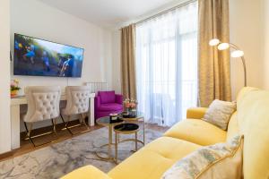 a living room with a yellow couch and two chairs at Belgrade Waterfront Studio Apartment-Supertwins in Sajmište