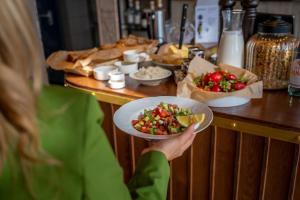 a woman holding a plate of food on a counter at Stay Eilat in Eilat +24 photos