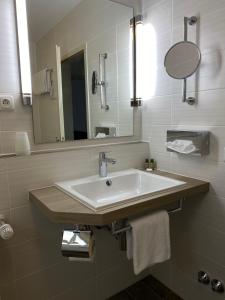 ein Bad mit einem Waschbecken und einem Spiegel in der Unterkunft Zur Rennbahn in Drage