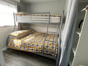 a bunk bed in a small room with a bunk bedutenewayangering at East Coast Chalets 57 at California Sands in Scratby +39 photos