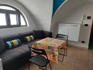 un soggiorno con divano e tavolo con sedie di Casa Relax a Porto Cesareo