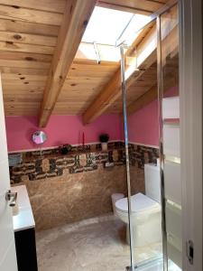 Camera con soffitti in legno e bagno con servizi igienici. di Casa Aurora 