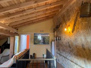 un soggiorno con soffitti in legno e un muro in pietra di Casa Aurora 
