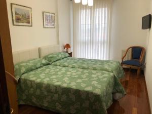 A bed or beds in a room at PISO con GARAJE en AVILES