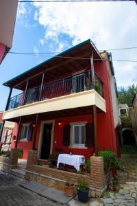 a red house with a table in front of it at Aggelina's House by GuestCorfu in Kynopiástai