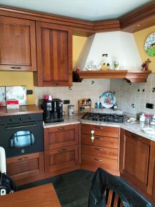 una cucina con armadi in legno e piano cottura. di Bernina Apartament a Chiesa in Valmalenco