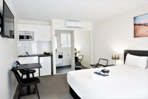 ein Hotelzimmer mit einem Bett und einer Küche in der Unterkunft Petrie Mill Motel in Petrie
