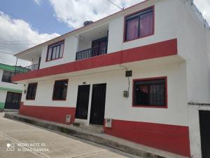 - un bâtiment blanc et rouge avec un balcon dans l'établissement Hospedaje Bolivar Alcala, à Alcalá
