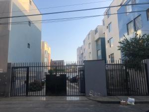 a black fence in front of some buildings at Qurpawasi in Lima