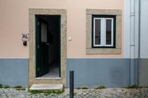 um edifício com uma porta preta e uma janela em Ajuda - Apartments em Lisboa