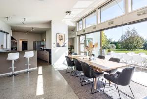 an open kitchen and dining room with a wooden table and chairs at Paradise on Campbell in Martinborough